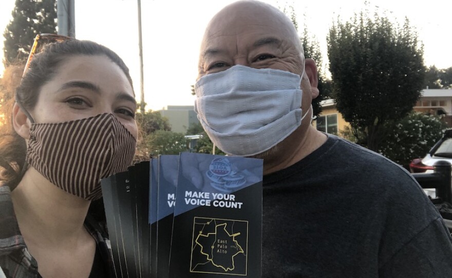 two masked people distribute KALW voter guides